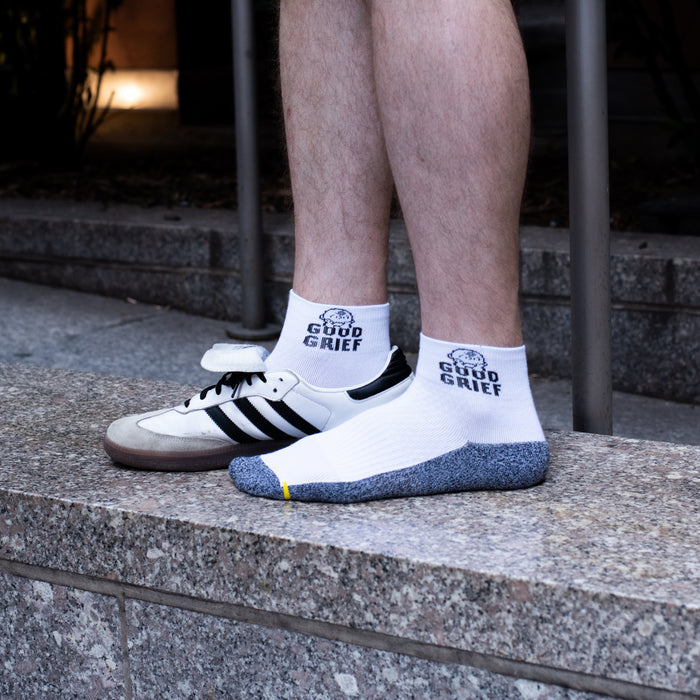White and black marled quarter compression socks for men with a Good Grief design, worn in a lifestyle setting.
