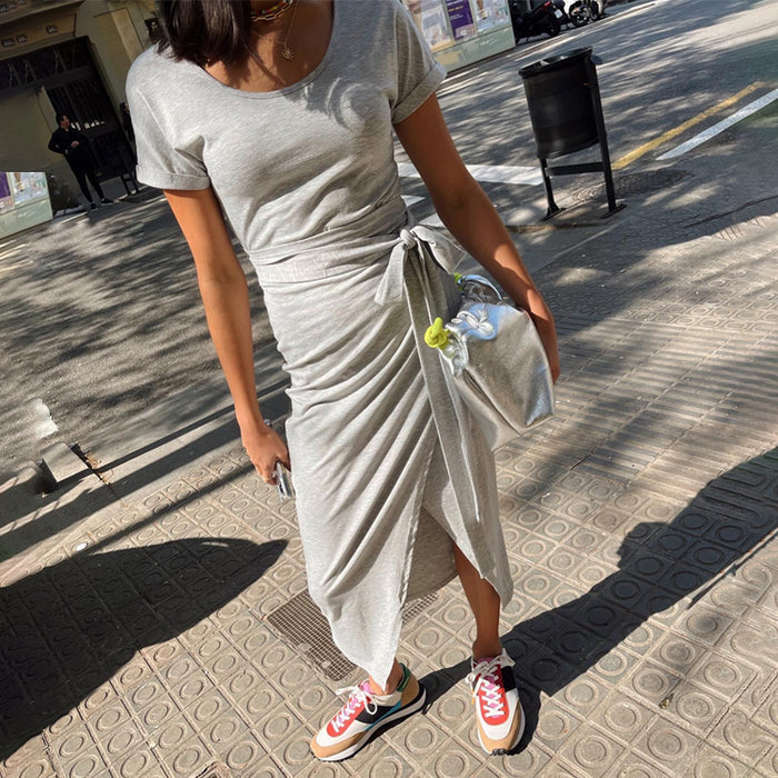Grey Jesse Jersey Wrap Dress in a marl jersey with a wrap tie waist and short sleeves, styled with trainers.