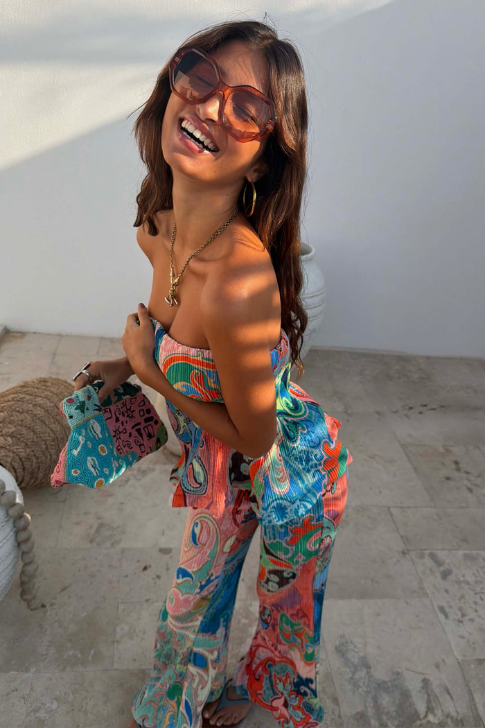 Hexagon Orange Sunglasses with light-tinted lenses, styled with a colourful patterned co-ord and beaded clutch bag.
