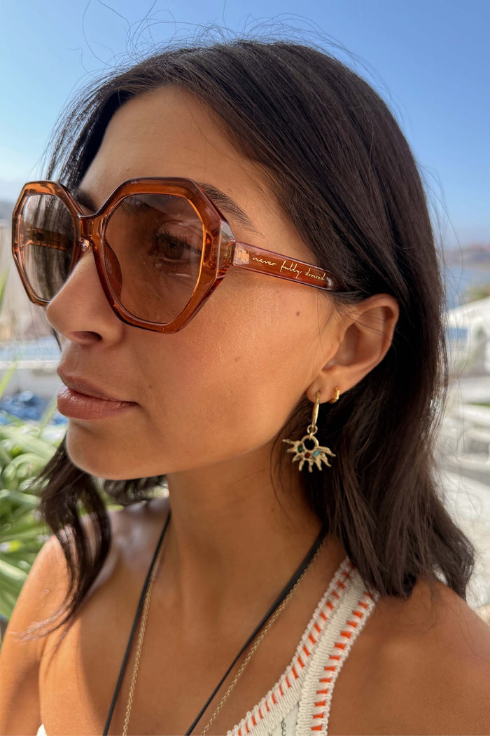 Hexagon Orange Sunglasses with light-tinted lenses and script branding on the side, worn by a model.