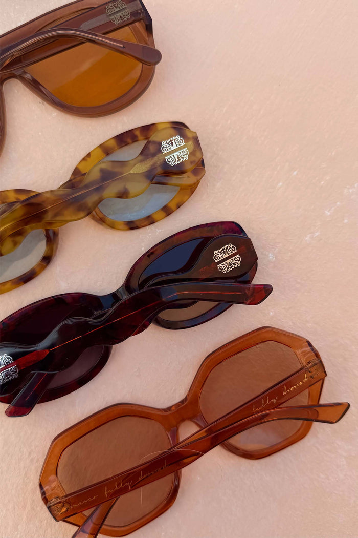 Hexagon Orange Sunglasses with light-tinted lenses and script branding, displayed alongside other NFD shades.
