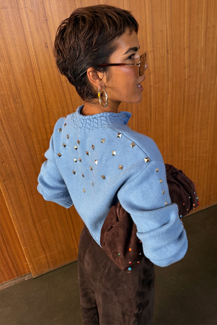 Ice Blue Studded Cardigan with silver metal studs on the back and sleeves, shown from a side view.