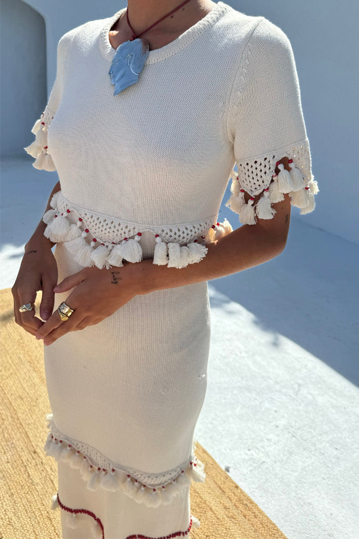 Ivory and Red Harper Dress featuring cream crochet knit, tassel details, and red bead accents.