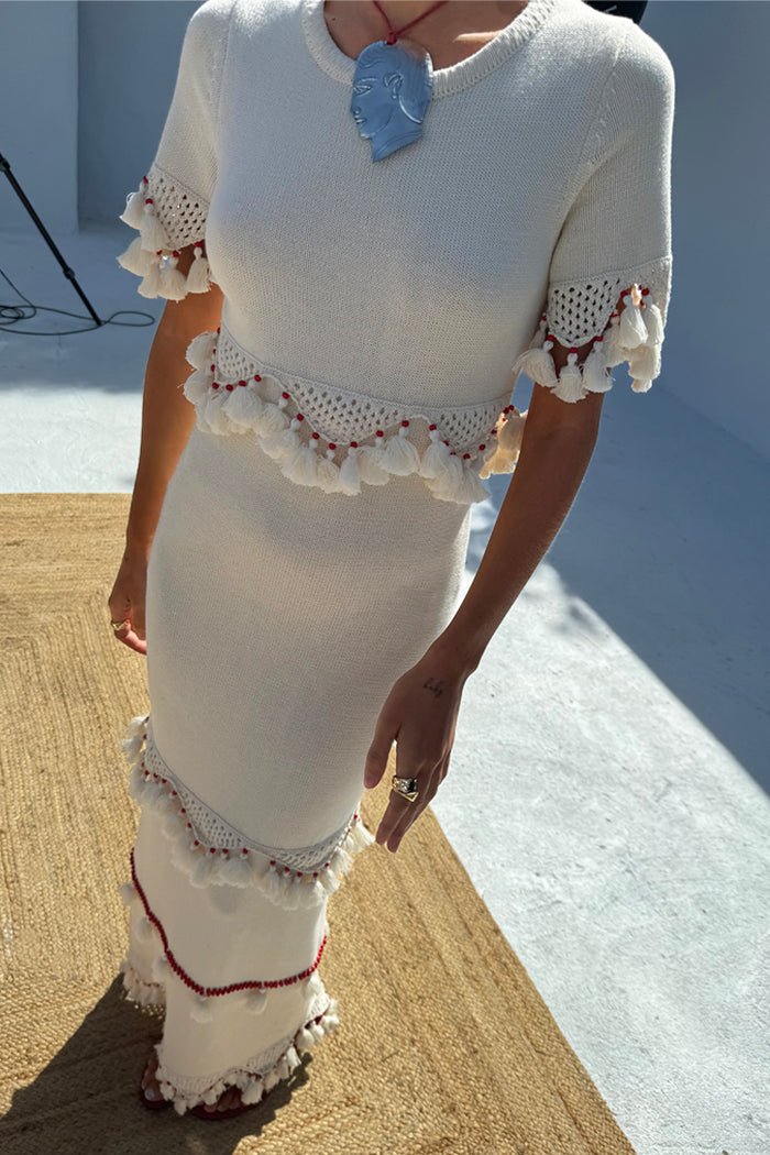 Ivory and Red Harper Dress featuring crochet scallop bands, tassels and red bead accents on a cream knit mid-axi.