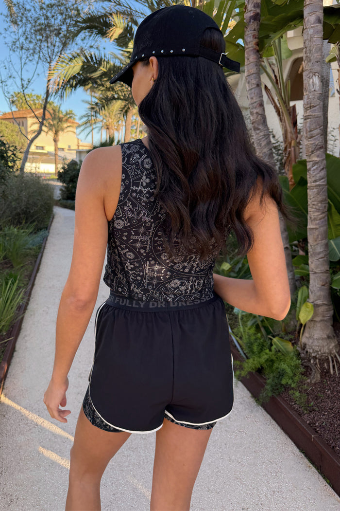 Black Map Running Short with 2-in-1 design and white piping, worn with a matching printed vest and cap outdoors.