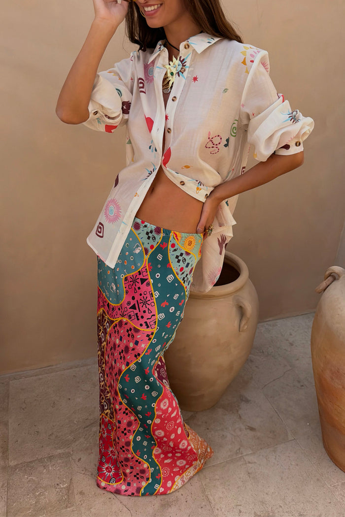 Morocco Charms Marley Shirt in sheer cream with sun and snake motifs, paired with a colourful patterned maxi skirt.