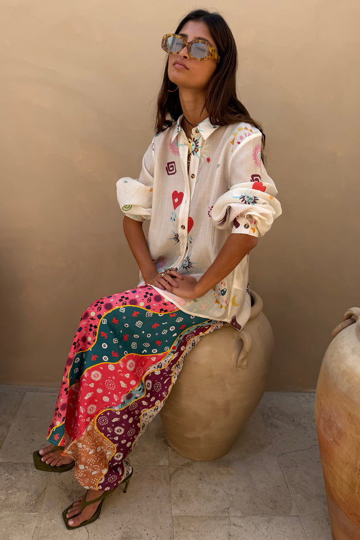 Morocco Charms Marley Shirt in cream with red hearts and sun motifs, worn with a vibrant printed maxi skirt.