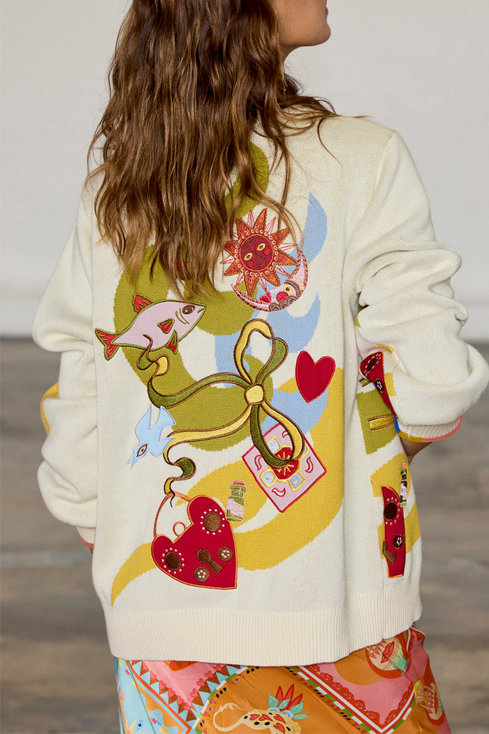 Cream Multi Enchanted Cardigan featuring colourful sun, heart and fish motifs on the back of a soft knit.
