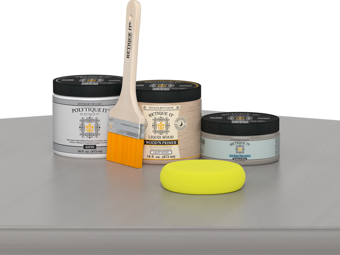 Retique It® Weathered Wood Multipurpose Kit contents with Liquid Wood primer, Weathered Wood gel stain alternative, PolyTique It® satin exterior top coat, paintbrush, and yellow sponge displayed on a gray wood surface.