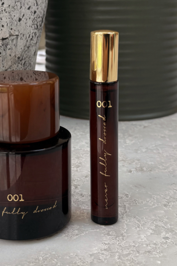 NFD Eau De Parfum 001 10ml travel-sized bottle in amber glass with a gold cap and signature gold script.