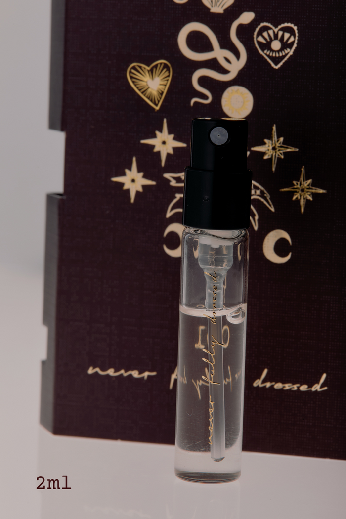 NFD Eau De Parfum 001 2ml tester vial with gold script on a dark celestial illustrated background.
