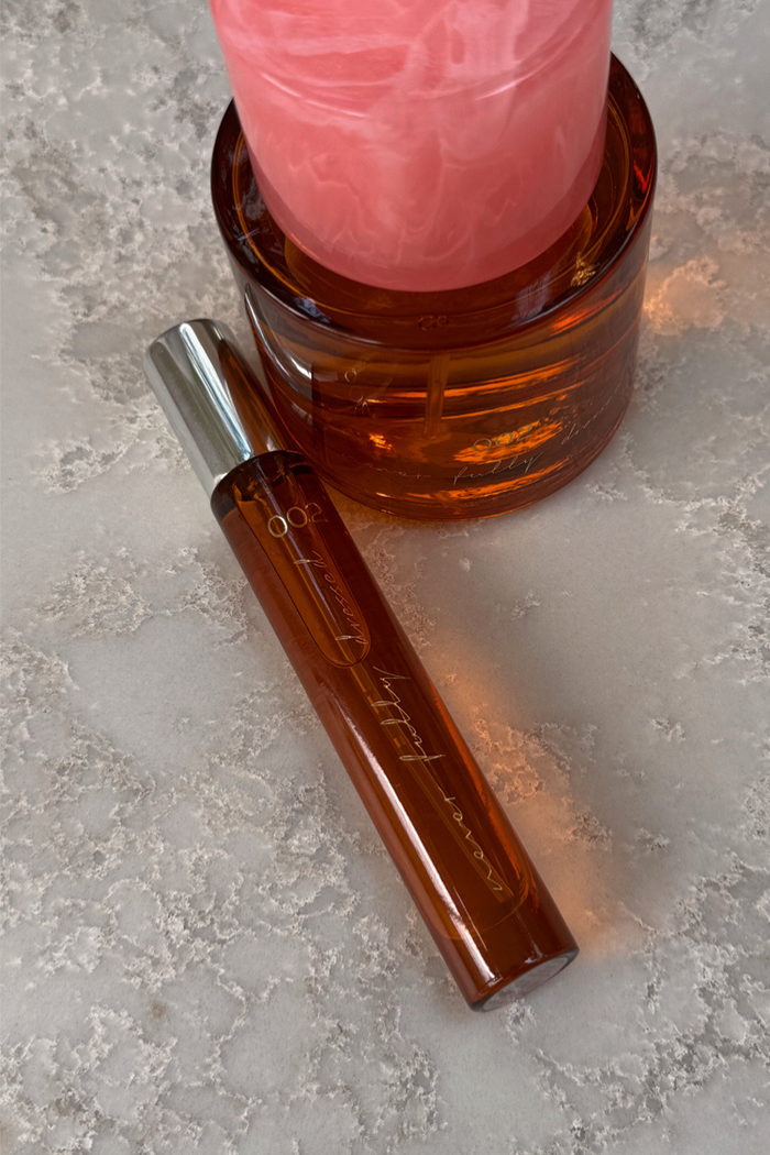 NFD Eau De Parfum 002 10ml travel spritz in an amber glass bottle with a silver cap on a textured stone surface.