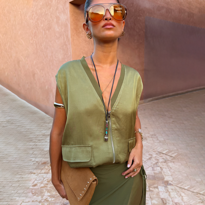 Olive Bubble Zip Vest in khaki green with a zip front, utility patch pockets and drawcord hem, styled for a vacation.