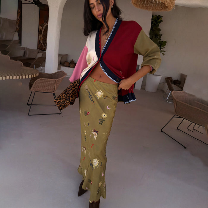 Olive Mystical Dorris Skirt with sun motifs on green viscose, paired with a colour-block cardigan and leopard clutch.
