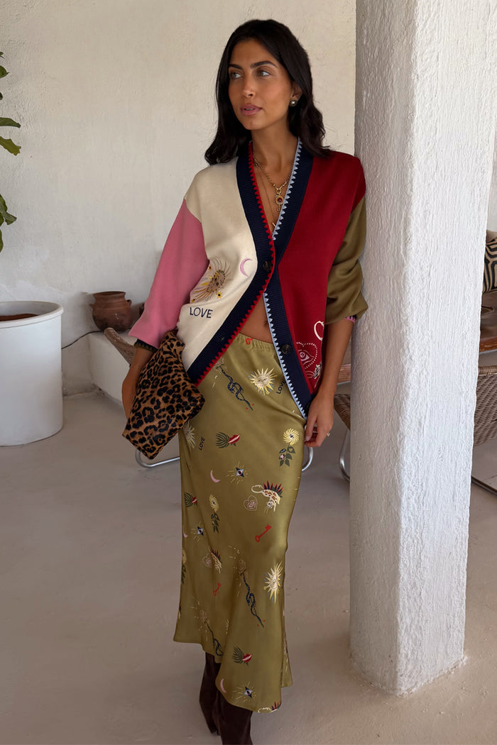 Olive Mystical Dorris Skirt in green with celestial motifs, styled with a colour-block cardigan and leopard clutch.