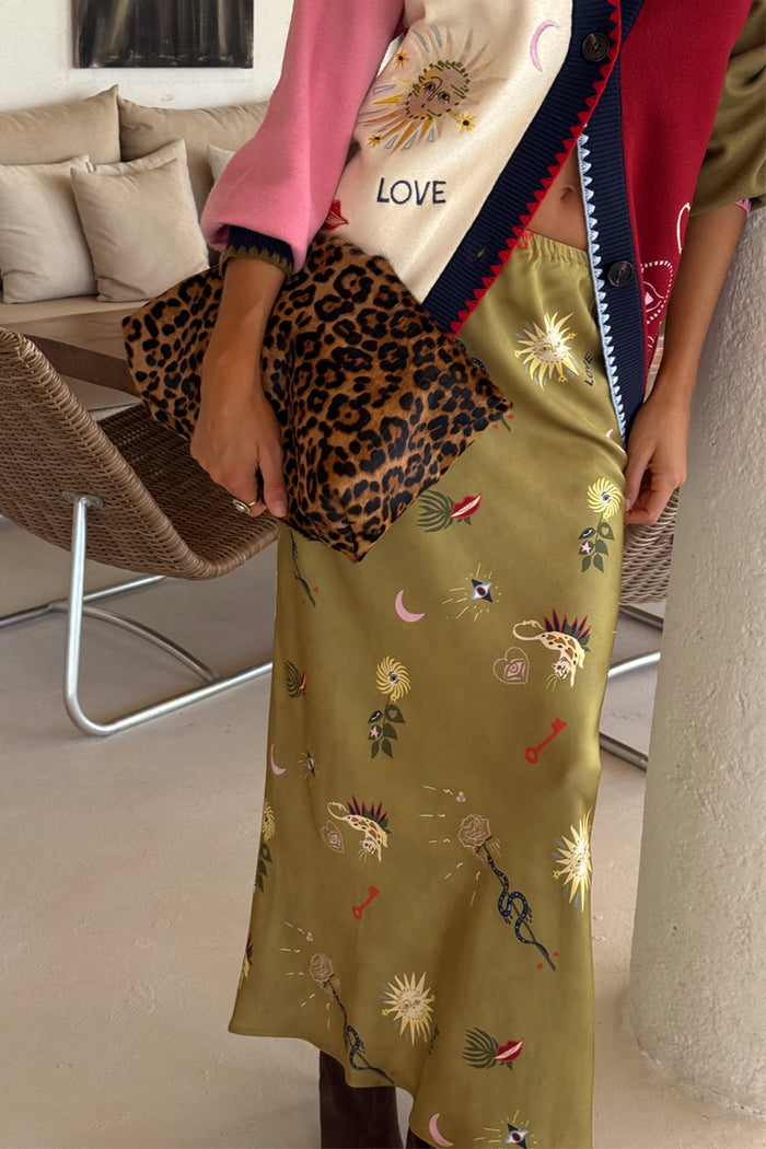 Olive Mystical Dorris midi skirt with celestial sun and moon motifs, paired with a statement leopard print clutch bag.