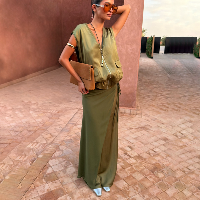 Olive Wrap Jojo Midi Skirt featuring matte and satin panels, styled with a matching utility vest and tan clutch.
