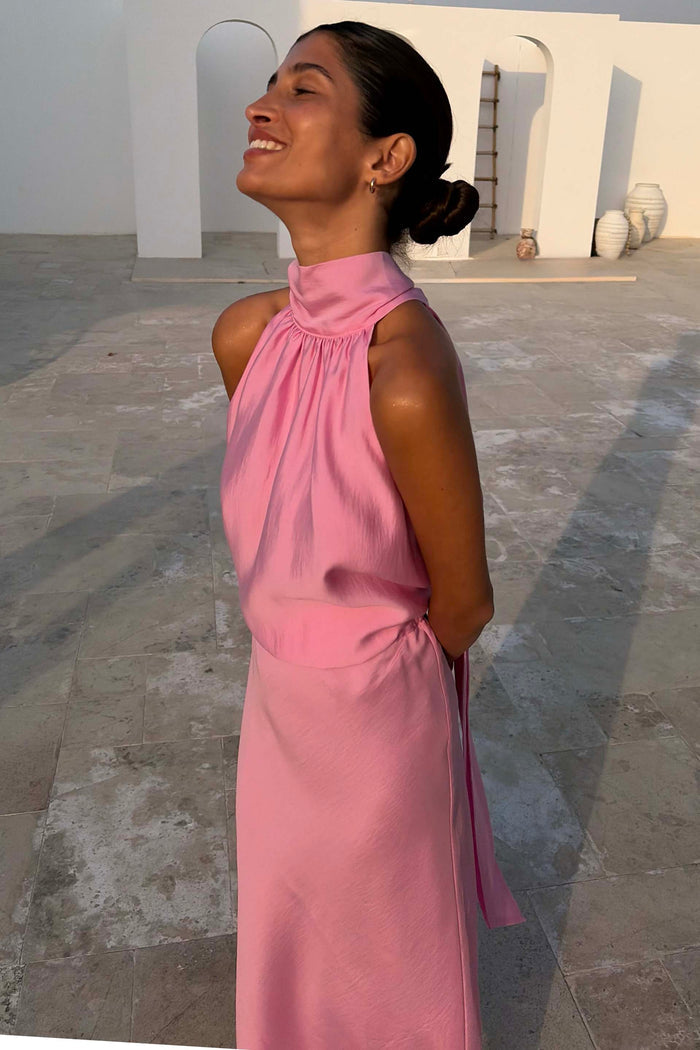 Pink Billie Top featuring a high gathered halterneck and draped fit in a soft pink shade, shown on a model.