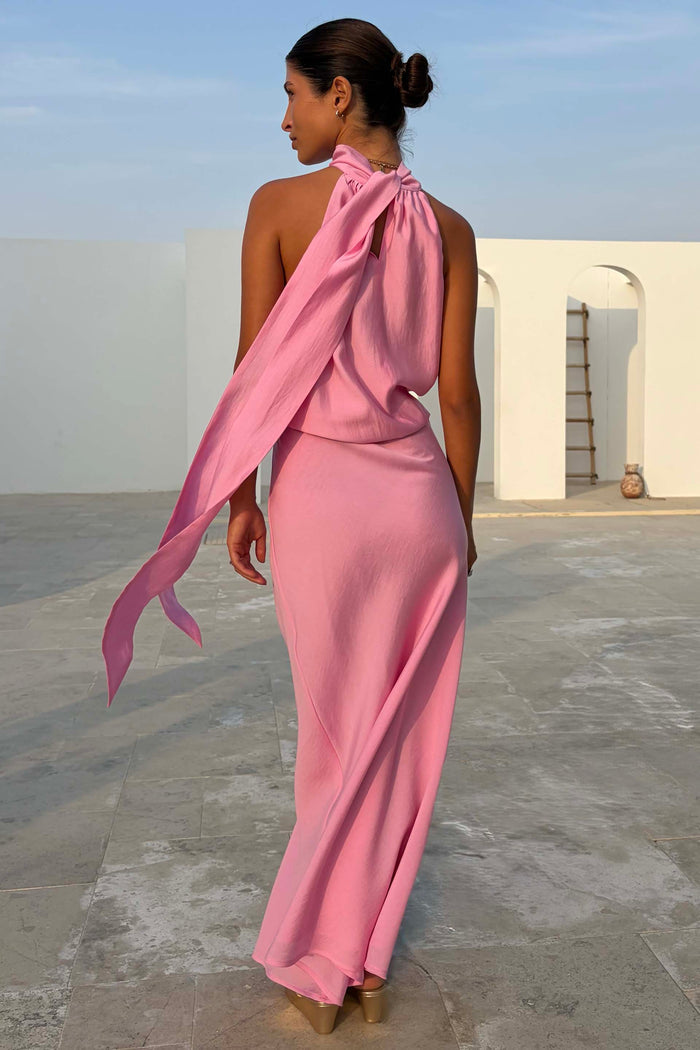 Pink Billie Top featuring a draped halterneck and long multi-wear tie detailing, styled with a matching pink skirt.
