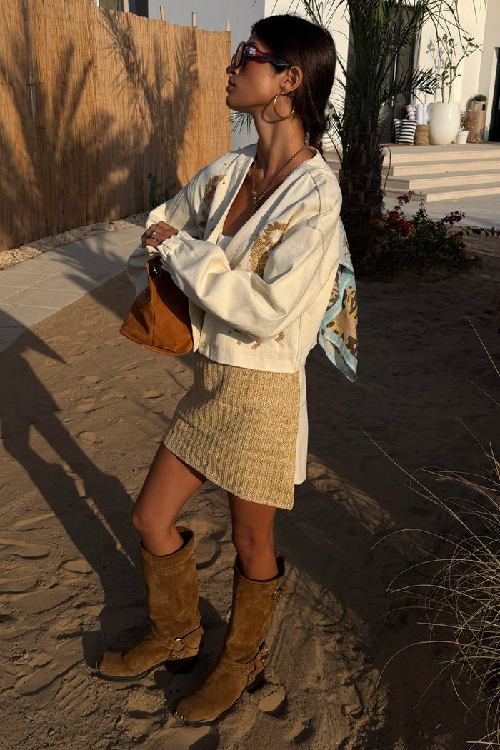 Cream Raffia Wrap Mini Skirt with a textured front panel, styled with a matching jacket and brown suede boots.