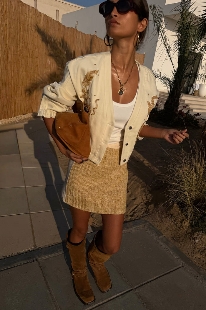 Cream Raffia Wrap Skirt with a textured front panel and wrap tie, styled with an embroidered jacket and brown boots.