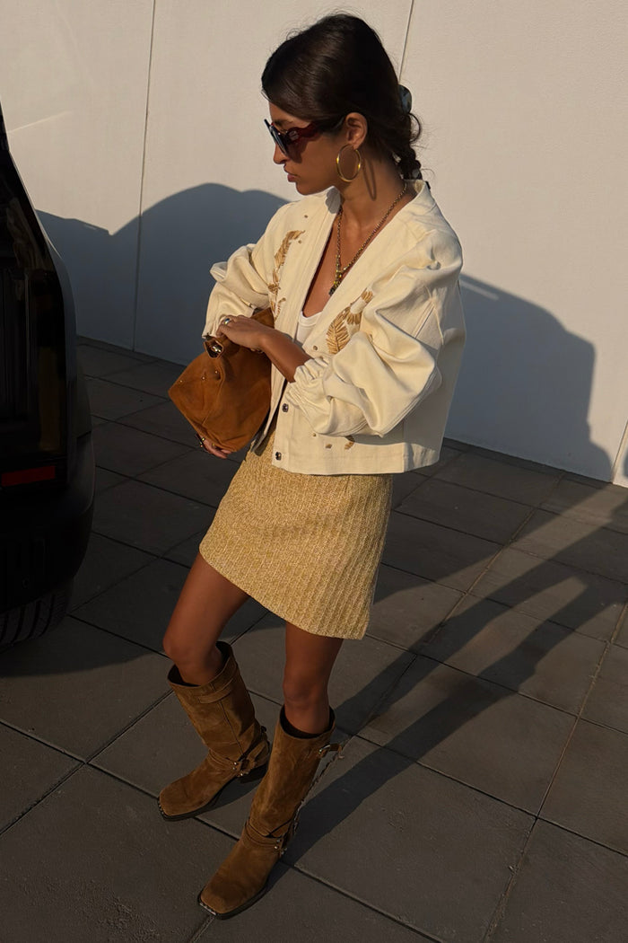 Cream Raffia Wrap Skirt styled with an embroidered jacket and brown suede boots for a textured London look.