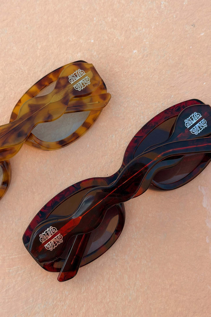 Red and amber tortoise acetate sunglasses featuring statement wiggle arms and NFD branded detailing.