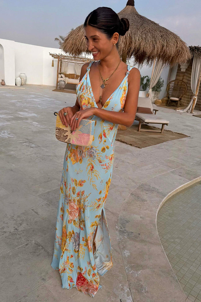 Sky Blue Floral Sofia Dress with tie-knot shoulders and side slit in a poolside vacation setting.