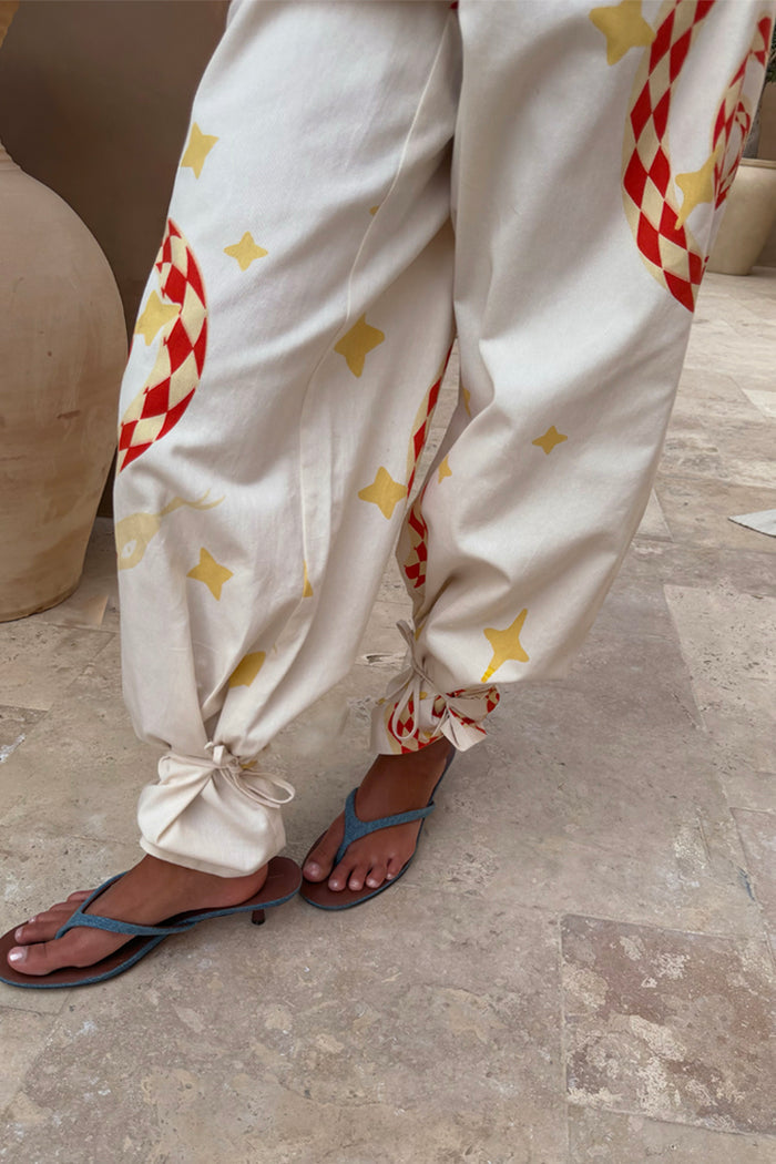Snake Tie Side Trousers in white cotton with red snake and star motifs and multi-wear tie-ankles.