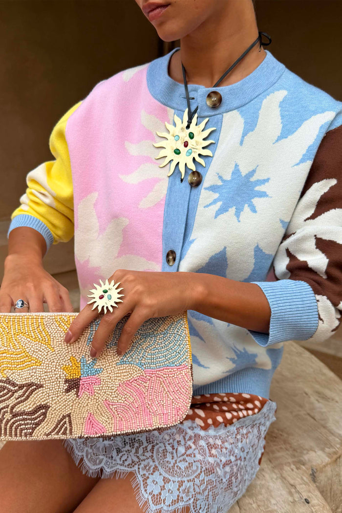 Soleil Hollie Cardigan featuring iconic pastel sun motifs and soft touch knit, styled with a beaded clutch.