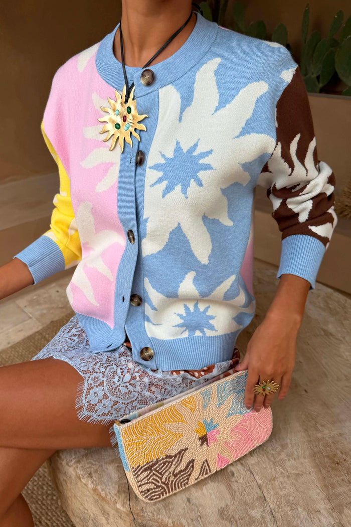 Soleil Hollie Cardigan in pastel tones with sun motifs, styled with a blue lace skirt.