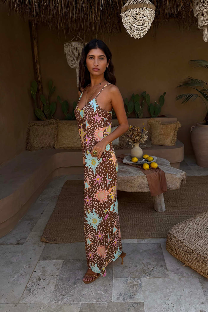 Star Fawn Aria Mesh Dress in a brown fawn spot print with sun and star motifs, styled in a rustic lounge setting.