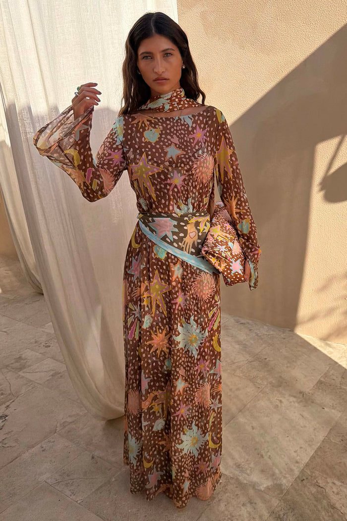 Star Fawn Aria Mesh Dress with a brown fawn spot print, celestial motifs and flared sleeves in a sunlit setting.