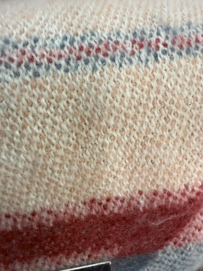 Oversized throw blanket knit texture with red and blue striped pattern on off-white