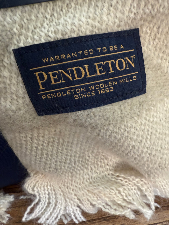 Throw blanket woven brand label: Pendleton logo and care text on beige fabric