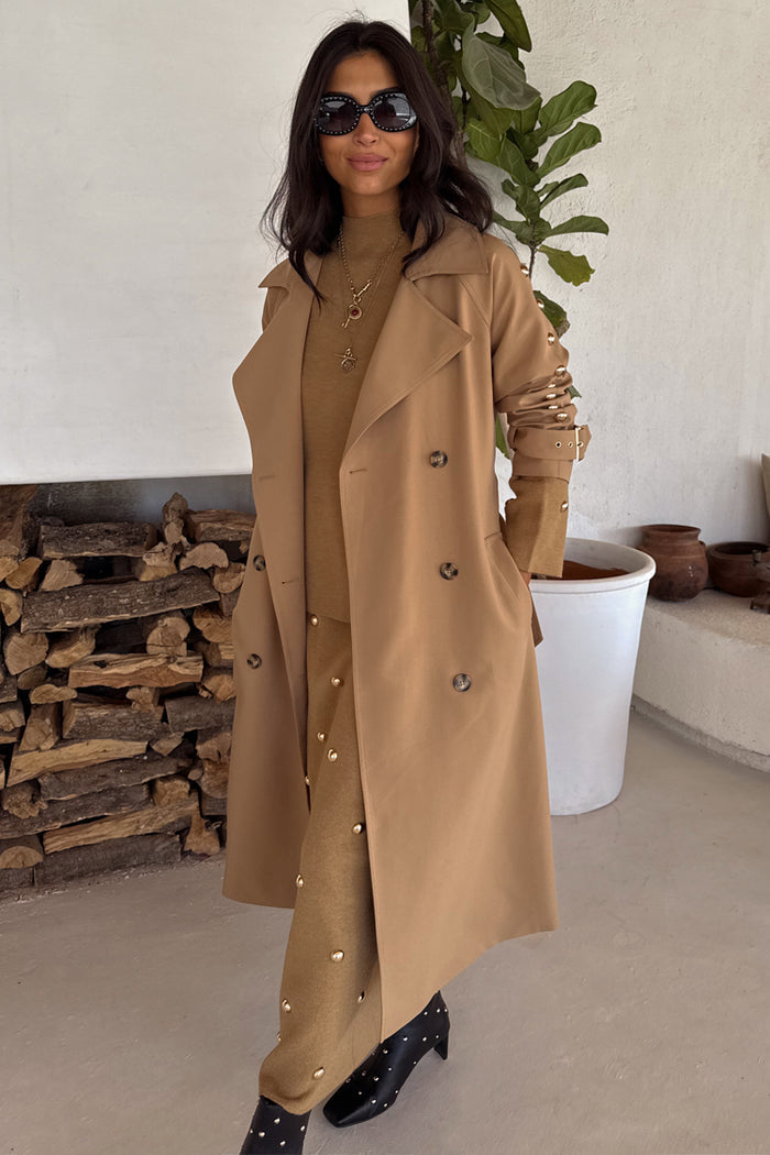 Tan Trench Coat with gold stud sleeve details, styled with a matching co-ord and black boots.