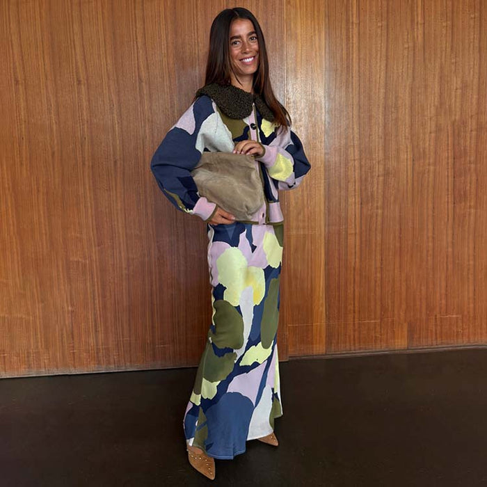 Teal Mara Abstract Dorris Skirt and matching cardigan with a borg collar, styled with a tan clutch and heels.