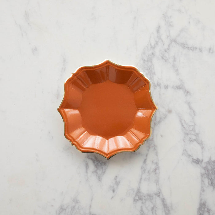 An orange scalloped paper plate.