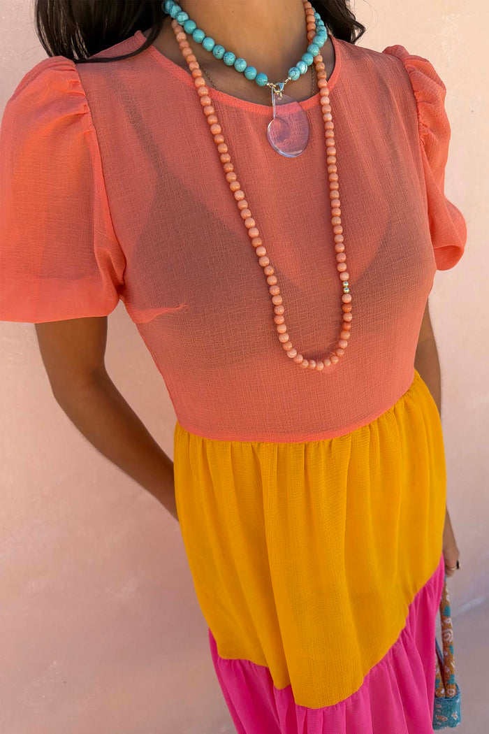 Tiered Abigail Dress in orange, yellow and pink with a sheer bodice and short puffed sleeves.