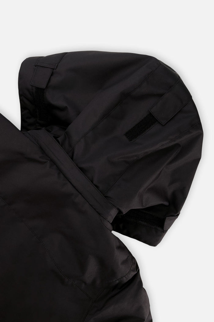 Close-up of the black helmet-compatible hood on the red and black Deux par Deux TEKNIK jacket