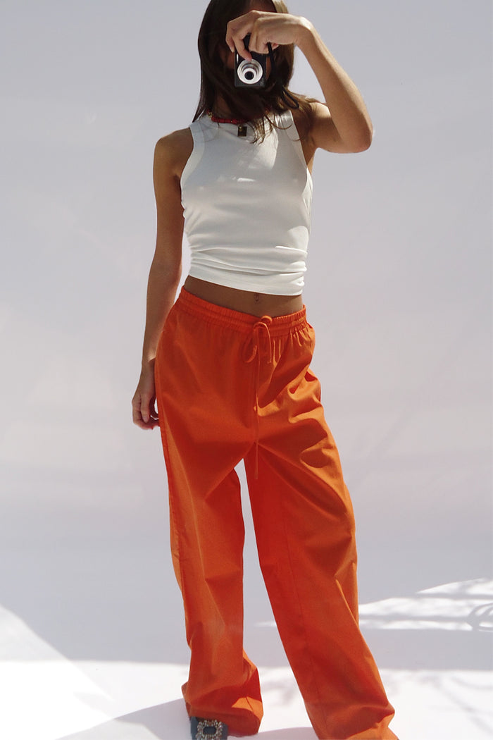 White Ribbed Tank styled with orange trousers for a casual London look, shown on a model taking a selfie.